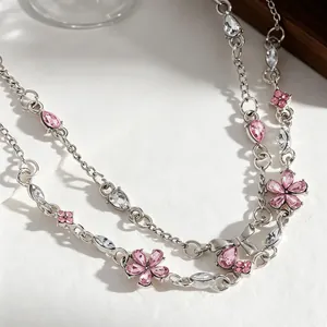 Detailed close-up of a silver-toned floral bracelet with pink crystals and a bow charm.