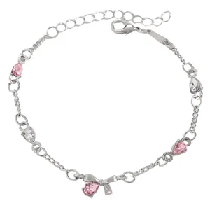 Detailed view of a silver bracelet featuring pink water-drop zircons and a bow charm.