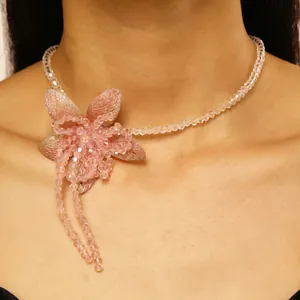 Close-up view of a pink beaded flower necklace with sweet holiday style on model.