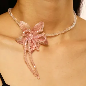 Close-up shot of elegant pink fabric flower necklace with sparkling beaded details