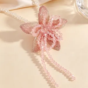 Detailed macro shot of a pink beaded flower pendant necklace with shimmering tassels.