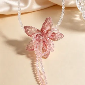 Macro view showing the intricate pink beaded flower pendant with woven mesh petals