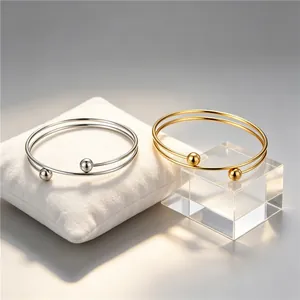 Close-up of gold and silver minimalist stainless steel double-loop bead bracelets.