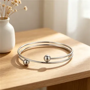 Close-up view of a minimalist stainless steel double-layered bangle with steel beads