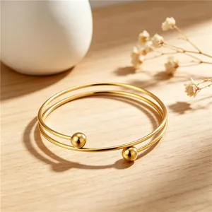Detailed view of a minimalist gold-plated stainless steel double-loop ball bracelet.