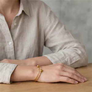 Close-up of minimalist gold stainless steel double-loop bracelet on woman's wrist