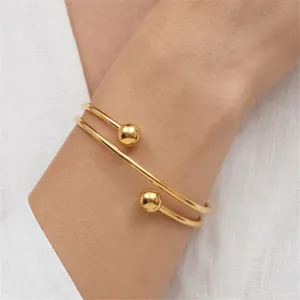 Detailed shot of a gold double-layer stainless steel bead bangle on a person's wrist