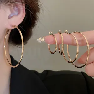 Dettaglio macro che mostra varie dimensioni di eleganti orecchini a cerchio oro.