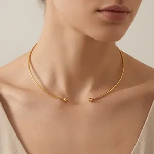 Close-up of a minimalist gold C-shaped titanium steel open choker necklace on model