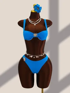Vue détaillée d'un bikini bleu avec des accents de soleil dorés sur un mannequin marron