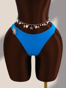 Détail d'un bas de bikini bleu sexy avec chaîne de taille en coquillages et étoiles de mer.