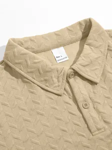 Close-up of beige men's jacquard polo shirt showing fabric texture and size label
