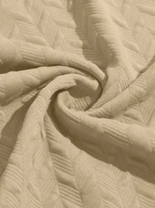Close-up detail of beige jacquard breathable fabric with herringbone texture for polo shirts