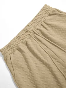 Detail of men's beige jacquard shorts featuring elastic waistband and drawstring.