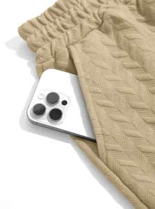 Close-up of men's beige jacquard shorts featuring a functional side pocket detail.