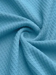 Detailed macro view showing the soft blue waffle knit fabric texture for men's polo