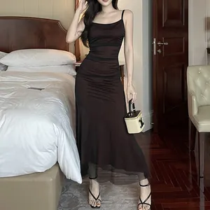 Elegant slim fit brown camisole maxi dress with mesh hem shown in a bedroom setting