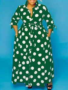 Detail of a plus size green maxi shirt dress with white polka dot print and pockets.