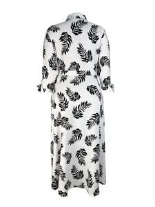 Back view of elegant white maxi shirt dress with black leaf print and tied cuffs.