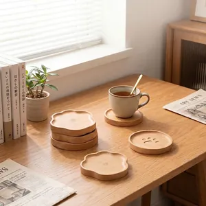 Detail view of Japanese beech wood coasters with bear paw and flower shapes on wooden desk