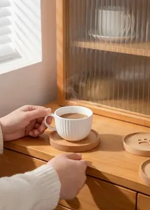 Detail view of a beech wood bear paw coaster with a white ceramic textured coffee mug