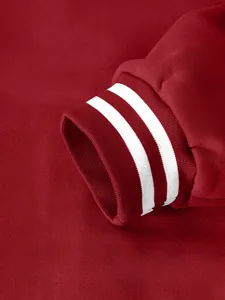 Macro detail of a red American varsity jacket cuff featuring white striped ribbed design