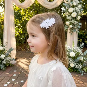 Detalle de una pinza para el pelo con flores de encaje bordado blanco para una niña.