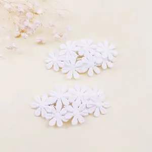 Primer plano de pinzas para el cabello con flores bordadas para niñas