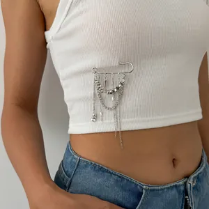 Gros plan d'une broche épingle de nourrice argentée tendance avec des chaînes à pompons
