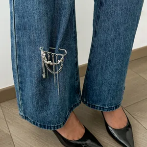 Détail de la broche à chaîne à glands CCB irrégulière épinglée sur un jean bleu