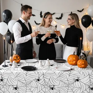 Close-up detail of a white spiderweb tablecloth used in a festive Halloween party setting