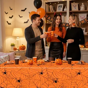 Festive orange Halloween tablecloth with spider web pattern used in party setting