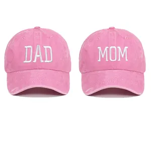 Detailed view of pink washed cotton baseball caps with DAD and MOM white embroidery