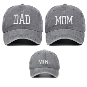 Detailed view of grey washed cotton family caps with DAD, MOM, and MINI embroidery