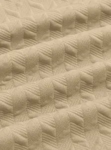 Detailed view of beige jacquard fabric with geometric herringbone pattern for men's Polo shirt