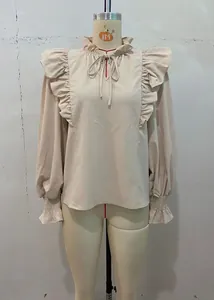 Close-up of beige blouse featuring elegant ruffles and tie-neck detail on mannequin.