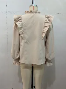 Detailed back view of an elegant beige long-sleeved blouse with ruffled shoulders