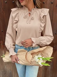 Detailed view of elegant beige ruffle long sleeve blouse with tie-neck and pleated cuffs