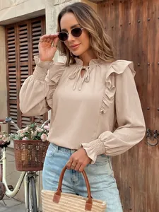 Close-up detail of elegant beige ruffle long sleeve blouse featuring a stylish high neck design