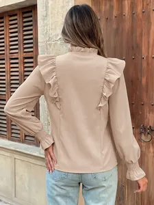 Back view of an elegant beige blouse with delicate ruffle details and smocked cuffs.