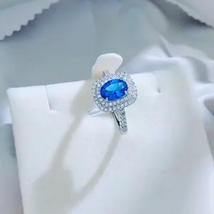 Elegant oval royal blue imitation sapphire ring featuring a shimmering halo of diamonds.