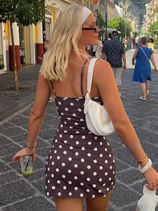 Robe courte moulante de style français à pois marrons dans un décor urbain chic