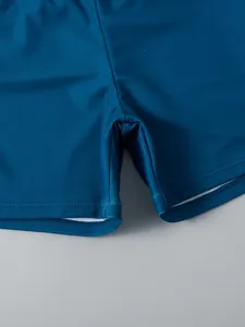 Close-up of boys' quick-dry swim shorts showing reinforced stitching and fabric detail.