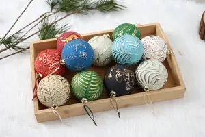 Detailed close-up of mixed pattern painted Christmas balls arranged in a wooden tray