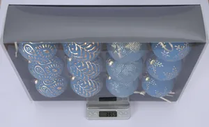 A set of twelve blue and gold 8cm Christmas baubles weighed on a digital scale