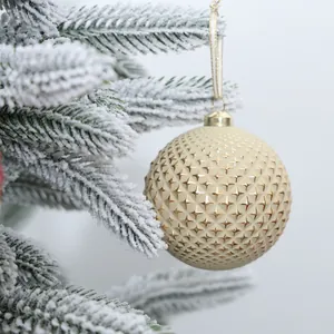 Macro view of champagne Christmas ornament with star texture on a frosted pine tree