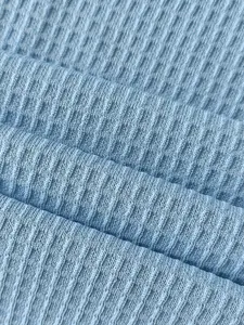 Gros plan sur la texture du tissu en maille gaufrée bleu clair