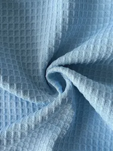 Gros plan détaillé montrant la texture gaufrée d'un tissu de sweat-shirt à capuche bleu