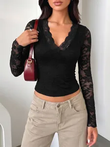 Close-up of black lace long sleeve V-neck top showing sheer floral patterns and slim fit.