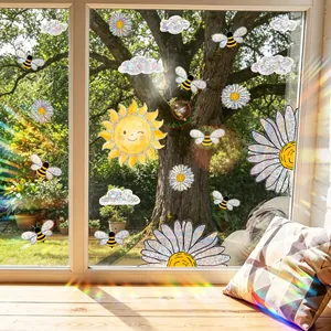 Close-up of rainbow prism window stickers with daisy and sun designs on glass.